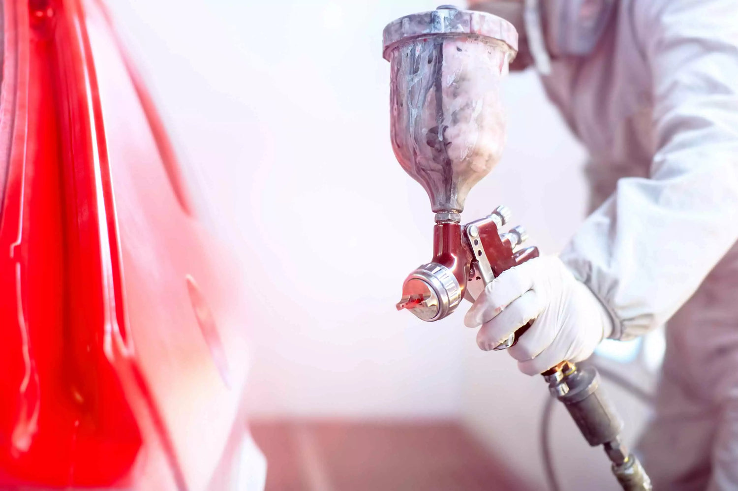 A person in a white suit and gloves operating an industrial air cleaner to ensure clean shop air.