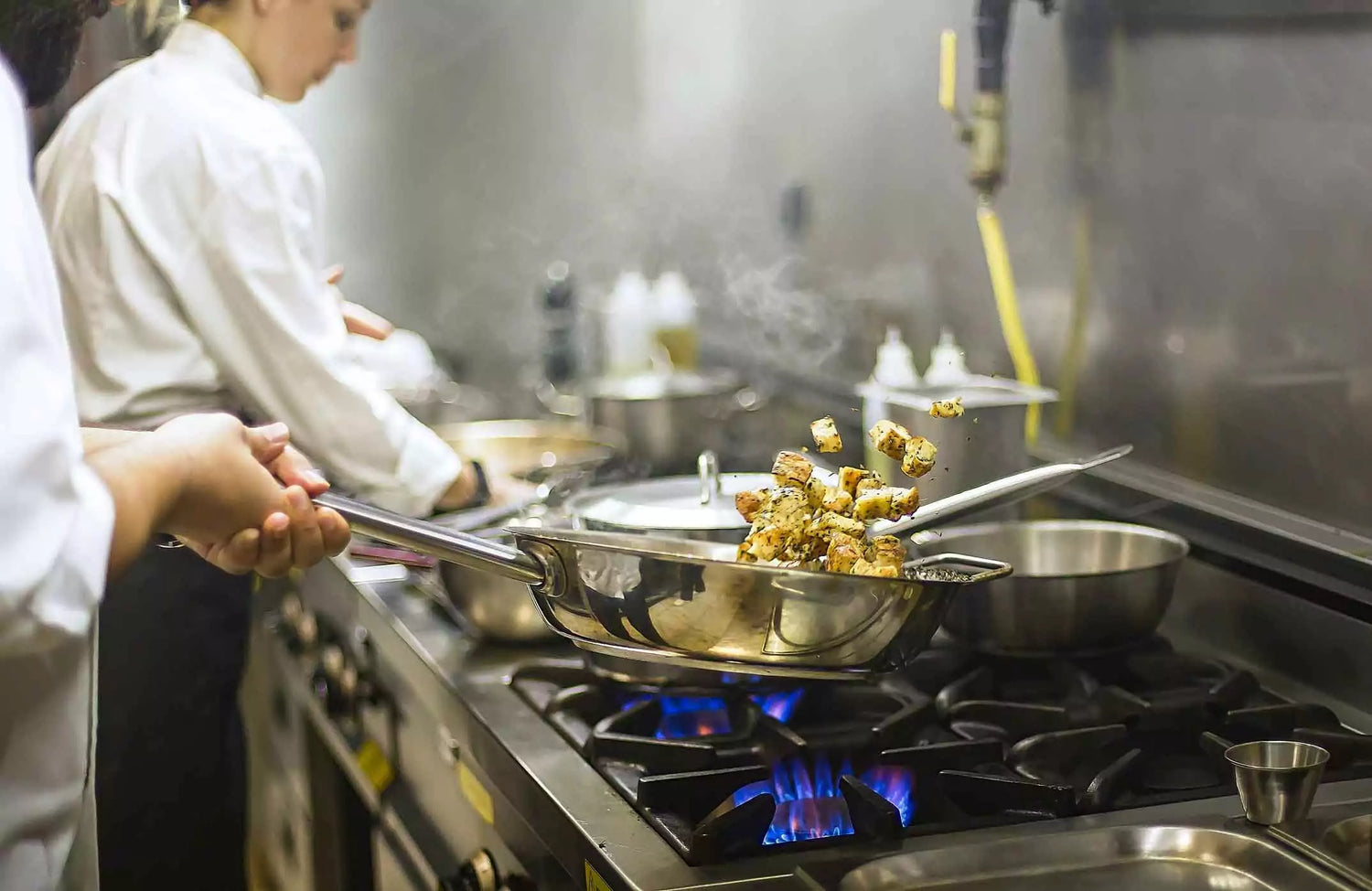 A person cooking food in a pan with clean shop air.