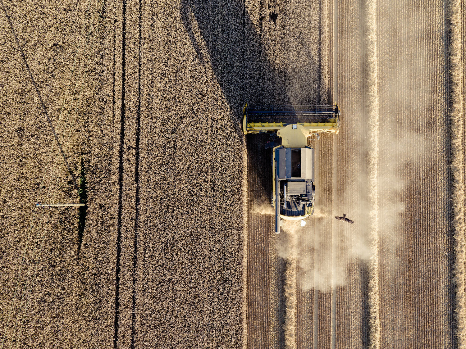 A machine using an industrial air purifier harvests a field, ensuring clean air.