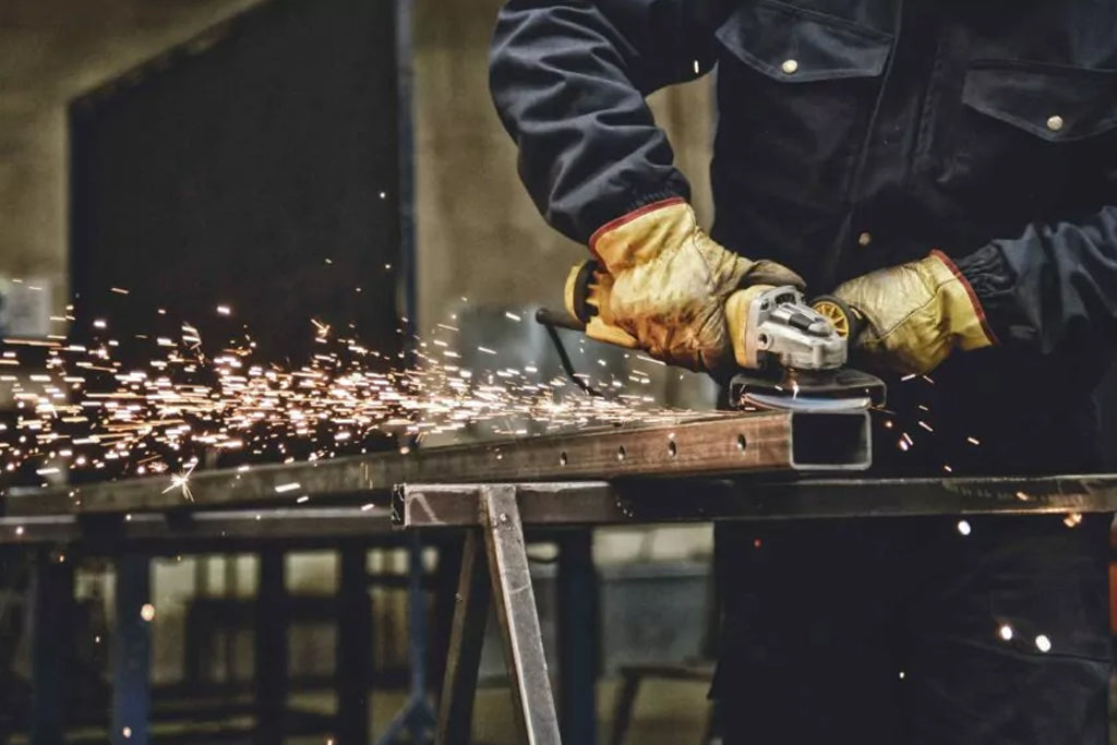 A man working with a grinder in an industrial factory with clean shop air.