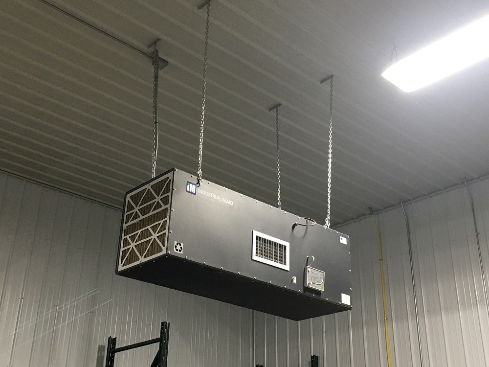 A large rectangular industrial air purifier hanging from a ceiling.