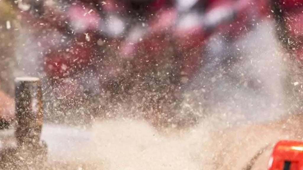 A man is using a saw to cut a piece of wood in a clean shop air environment, aided by an industrial air purifier.